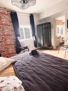 1 dormitorio con cama y pared de ladrillo en Suite en Terrasse à Cognac, en Cognac