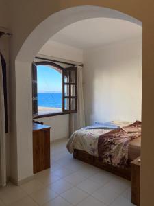 a bedroom with a bed and a view of the ocean at Dahab , property company Lighthouse area in Dahab