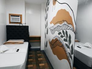 a room with two beds and a chair in it at FB Dormitel Suites in Cagayan de Oro
