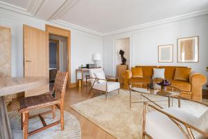 ein Wohnzimmer mit einem Sofa und einem Tisch in der Unterkunft Hôtel Madison in Paris