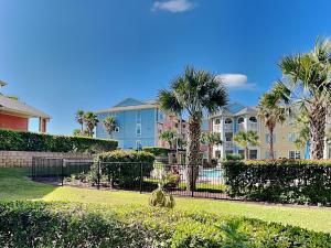 a large apartment complex with palm trees and bushes at Dawn 315-saltwater Escape in Galveston
