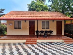 una piccola casa con sedie di fronte di Sunny Smiles a Mangalore