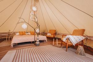 Habitación con tienda de campaña, cama y sillas en Glamping Černická obora, en Sudoměřice