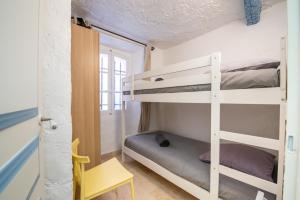 a room with two bunk beds and a chair at Appartement vieux village - La Ponche in Saint-Tropez