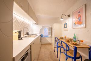 a kitchen with a table and blue chairs in it at Appartement vieux village - La Ponche in Saint-Tropez