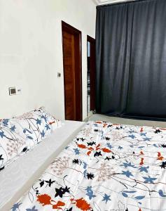 Una cama con un edredón con hojas de otoño. en Spacious Private Room & Balcony In Cotonou, en Cotonou