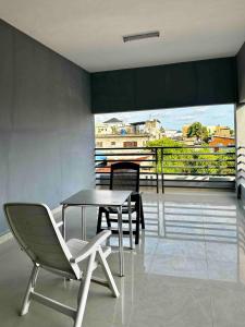 comedor con mesa y sillas en el balcón en Spacious Private Room & Balcony In Cotonou, en Cotonou