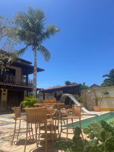 een patio met een tafel en stoelen naast een zwembad bij Quarto com banheiro no térreo in Araruama
