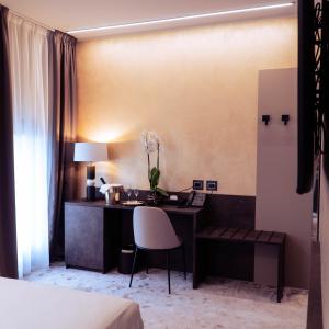 a hotel room with a desk and a chair at Hotel De Amicis in Moglia
