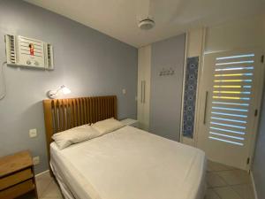 1 dormitorio con cama blanca, mesa y ventana en Ocean Flat 1006 en Vila Velha