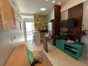 a living room with a couch and a tv and a kitchen at Ocean Flat 1006 in Vila Velha
