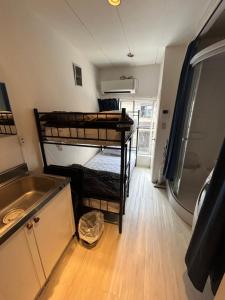 um pequeno quarto com dois beliches em Meguro Apartment em Tóquio mais 8 fotografias