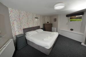 a bedroom with a white bed with a patterned wall at Harrogate Self Catering -Harrogate Convention View - Parking in Harrogate