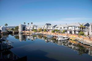 einen Yachthafen mit Häusern und Booten im Wasser in der Unterkunft Waterfront- C25 Knysna Quays with pool in Knysna