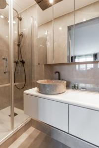 La salle de bains est pourvue d'un lavabo et d'une douche. dans l'établissement Magnifique Appartement avec vue sur la Tour Eiffel, à Bagneux