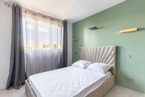 - une chambre avec un grand lit et une fenêtre dans l'établissement Magnifique Appartement avec vue sur la Tour Eiffel, à Bagneux