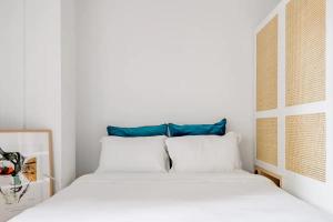 2 bedden in een witte kamer met blauwe kussens bij Blue City Center Boutique Apartment in Thessaloniki