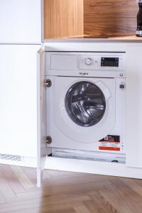 uma máquina de lavar roupa num armário numa cozinha em HM - Infante Riverside Apartment C no Porto
