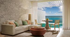 Sandals Regency La Toc All Inclusive Golf Resort and Spa - Couples Only في كاستريس: غرفة معيشة مع أريكة وإطلالة على المحيط
