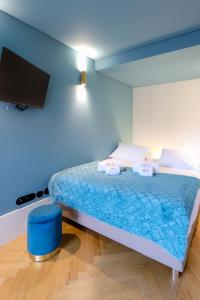 Habitación azul con cama y TV. en HM - Infante Riverside Apartment C en Oporto