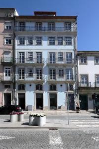 ein großes weißes Gebäude mit Fenstern auf einer Straße in der Unterkunft HM - Infante Riverside Apartment C in Porto