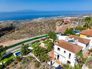 an aerial view of a house and the ocean at Villa con piscina privada, vistas y jardín in Guía de Isora
