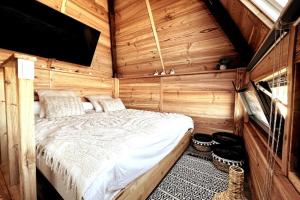 une chambre avec un lit dans une cabane en bois dans l'établissement Chalet et Jaccuzy sur la plage, à Biscarrosse