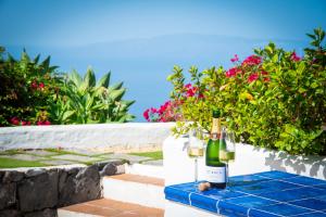 a bottle of wine and two glasses on a table at Villa con piscina privada, vistas y jardín in Guía de Isora