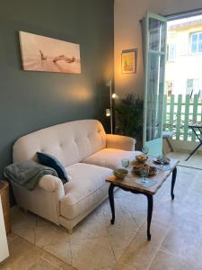 ein Wohnzimmer mit einem weißen Sofa und einem Tisch in der Unterkunft Bel appartement de 40m² à louer in Nizza