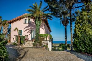 una casa con palmeras y el océano en el fondo en Agrumè Country House, en Santa Venerina