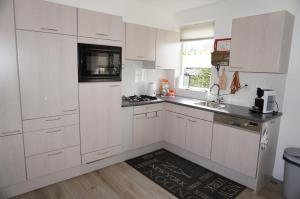 a kitchen with white cabinets and a sink at Kustverhuur, Park Scheldeveste , Schelde 095 in Breskens