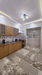 uma grande cozinha com armários de madeira e piso em azulejo em APARTMENT «СЕМЬЯ» em Tashkent