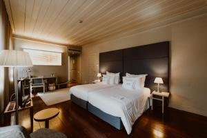 ギマランイスにあるホテル ダ オリベイラの大きなベッドとソファが備わるホテルルームです。