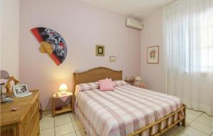 4 Bedroom Nice Home In Marina Di Modica في مارينا موديكا: غرفة نوم عليها سرير ومخدة وردية