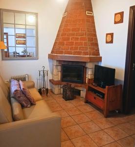 - un salon avec une cheminée, un canapé et une télévision dans l'établissement Casa El Aljibe, à Puntagorda