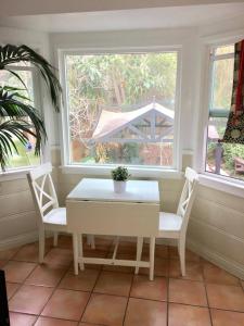 uma mesa e cadeiras num quarto com duas janelas em Echo Park Home with Yard Your Private Oasis in the Heart of LA! em Los Angeles
