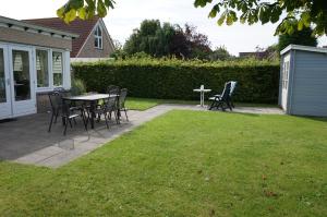 a patio with chairs and a table in a yard at Kustverhuur, Park Scheldeveste , Schelde 095 in Breskens
