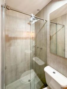 uma casa de banho com um chuveiro, um WC e um lavatório. em Hotel Posada de Santa Elena em Tunja