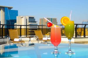 two cocktails sitting on a table on a rooftop at Transamerica Executive Faria Lima in São Paulo