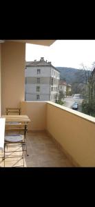einen Balkon mit einem Tisch und Stühlen sowie ein Gebäude in der Unterkunft Summer in Braşov