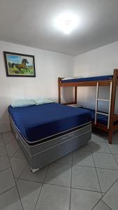 a bed in a room with a blue mattress at Acomodação Ruth Guaratuba in Guaratuba