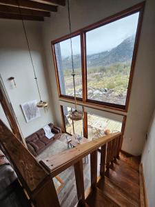 CABAÑAS LODGE LOS COIHUES 2 VALLE LAS TRANCAS/TERMAS DE CHILLAN /NEVADOS DE CHILLAN في Pinto: غرفة بها أريكة ونافذة كبيرة