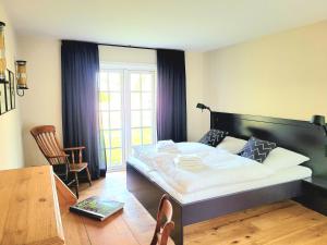 - une chambre avec un grand lit, une table et des chaises dans l'établissement Haus Renate, à Nieblum
