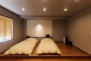 two beds sitting in a room with a screen at Stay UWU 001 ステイ ウー 001 in Kochi