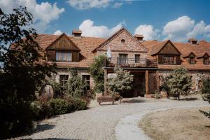 duży drewniany dom z dziedzińcem przed nim w obiekcie Żabi Dwór - HOTEL - RESTAURACJA - SPA w Zielonej Górze