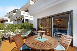 un tavolo in legno e sedie sul balcone. di Blue Dream Pebble Beach a San Miguel de Abona