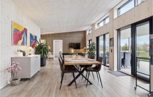 Øster HurupにあるGorgeous Home In Hadsund With Saunaのダイニングルーム(木製テーブル、椅子付)