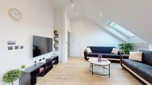 a living room with a couch and a tv at Penthouse Style Apartment in London