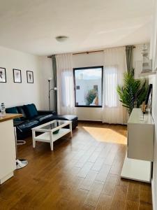 a living room with a couch and a table at Apartamento con amplia terraza en la playa in Puerto del Carmen