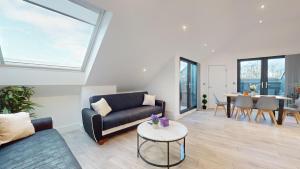 ein Wohnzimmer mit einem Sofa und einem Tisch in der Unterkunft Penthouse Style Apartment in London